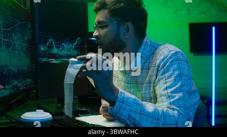 Arabian Indian man male guy programmer examining writing binary code coder freelancer engineer worker IT specialist monitor analyzing computer Stock Photo