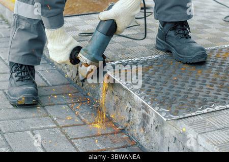 Processing of metal sheet with an angle-grinding tool. Production and industrial background Stock Photo