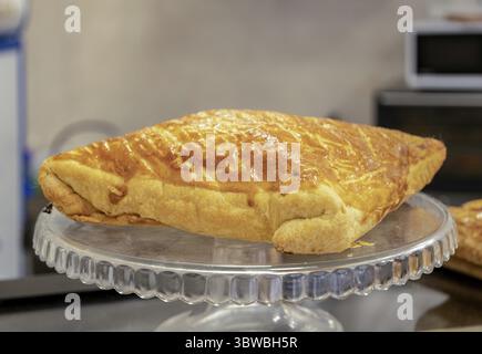 A fluffy puff pastry pie sits on a glass cake stand Stock Photo