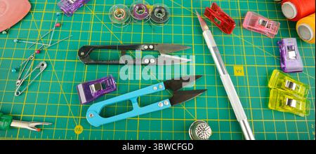 Different sewing supplies on green background, flat lay. Wide photo. Stock Photo
