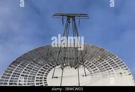 Old radio telescope on blue sky background. History of technology and progress. Radiowave sience, Observatories and scientific centers Stock Photo