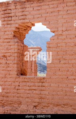 Close-up of irregular window in adobe wall. Through the opening, the mountainous landscape of Mayorazgo complex, Catamarca, Argentina, is visible. Stock Photo