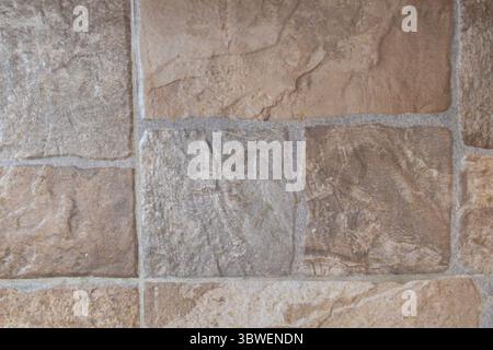 Rustic Textured Sandstone Wall with Weathered Mortar Joints in Warm Natural Tones. Stock Photo