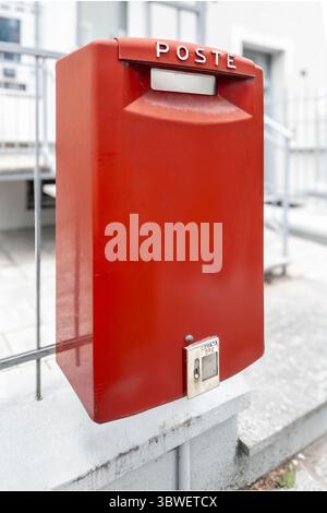 Red Italian Poste mail collection box on railing Stock Photo