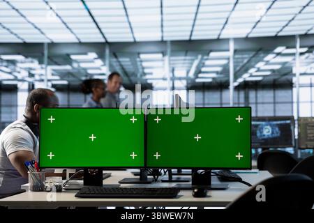 Man doing data center automation using AI and machine learning tools on mockup computer. Programmer integrating artificial intelligence driven automation in server hub operations using green screen PC Stock Photo