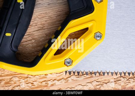 Closeup hand saw on wooden background. Tools for construction Stock Photo