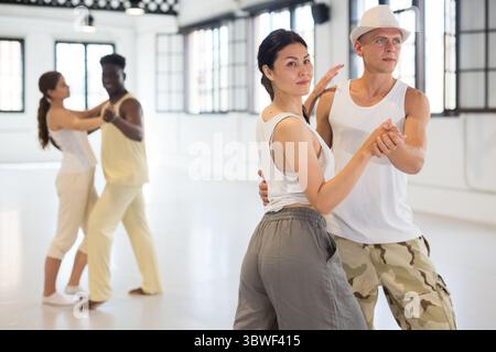 Four dancers exercising bachata movements Stock Photo