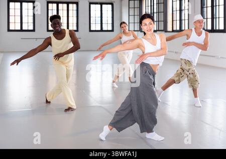 People practicing vigorous lindy hop movements in dance class Stock Photo