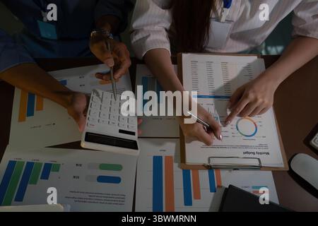 Data Review. Young professionals analyzing financial reports together in office. Stock Photo