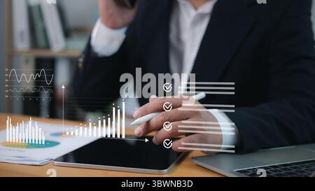 Professional analyzing business data on tablet with stylus while managing a digital checklist, representing market research, financial analysis, and e Stock Photo