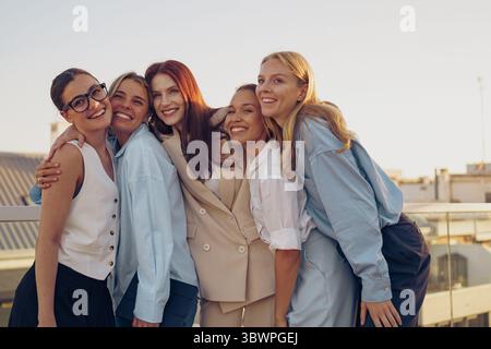 A cheerful group of diverse women joyfully posing together in an outdoor setting Stock Photo