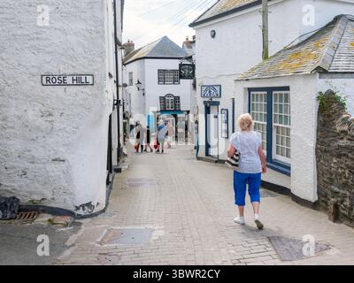 port isaac, england, 22 june 2025: old white houses and tourists in cornish village of port isaac on sunny spring day Stock Photo