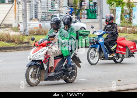 RATCHABURI, THAILAND, OCT 18, 2022, Delivery company workers transport packages in boxes and bags on motorbikes Stock Photo