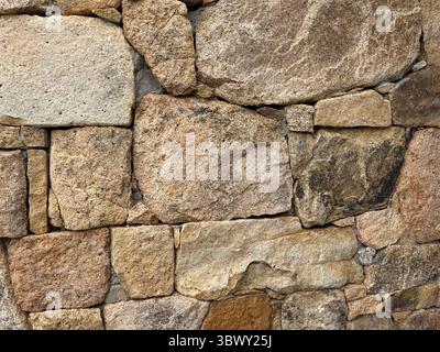 Close-up of irregular granite stones forming an old traditional wall Stock Photo
