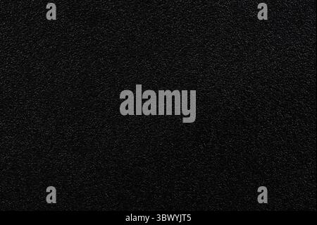 Black grainy plastic texture background pattern close up view Stock Photo