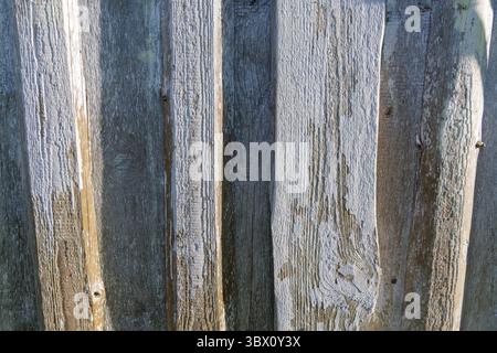 A close-up of vertically aligned, weathered wooden planks with varying textures and tones, perfect for rustic backgrounds. Stock Photo