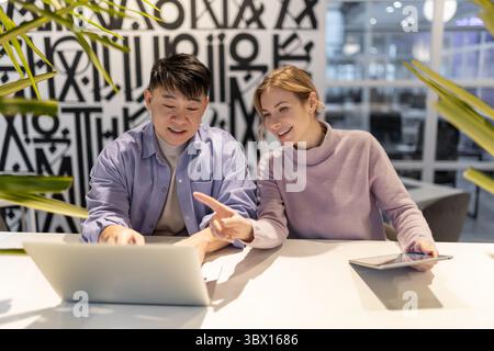 Young people working together on a project and looking involved Stock Photo