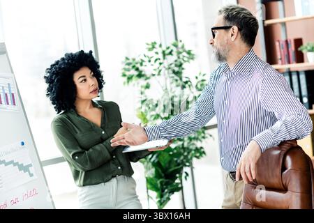 Business professionals collaborating on project goals and objectives during an office meeting in a modern workplace. Stock Photo