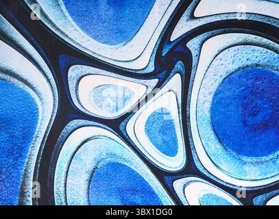 Abstract artwork featuring layered blue and white ovals with dark outlines, creating a fluid, cell-like pattern with a sense of depth and movement. Stock Photo