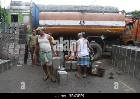 Kolkata, West Bengal, India. 17th July, 2025. Laborers pour cooking oil into tins at a wholesale market in Kolkata, India, on July 17, 2025 (Credit Image: © Rupak De Chowdhuri/ZUMA Press Wire) EDITORIAL USAGE ONLY! Not for Commercial USAGE! Stock Photo