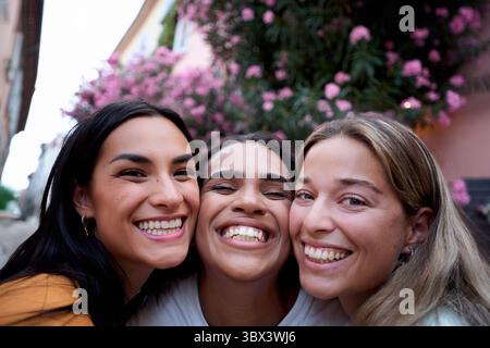 Three happy young women smiling together outdoors Stock Photo