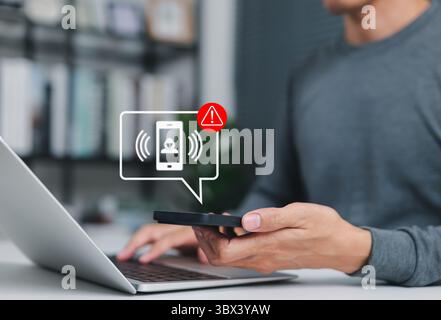Phone scam alert notification concept. A man holding smartphone with scam warning notification, fraudulent calls, cybersecurity threat, fraud, scammer Stock Photo