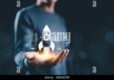 Startup Launch and Business Development Concept. Hand presenting glowing rocket icon with business symbols, representing startup launch, success, Stock Photo
