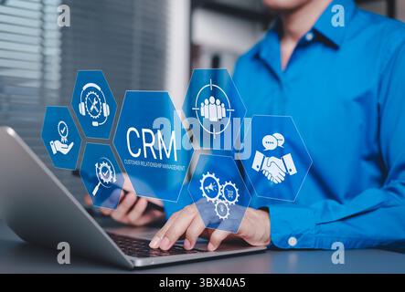 CRM Customer Relationship Management Concept. Businessman using laptop with CRM icons representing customer support, service, relationship building, Stock Photo