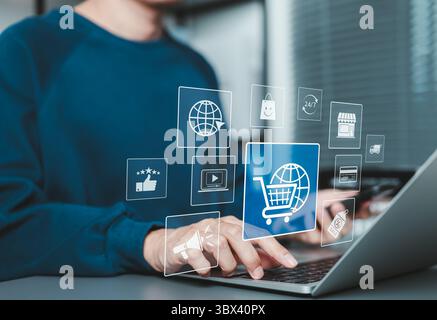 Online shopping and e-commerce concept. A man using laptop and phone with ecommerce icon, shopping cart, discount tag, and delivery truck, online shop Stock Photo