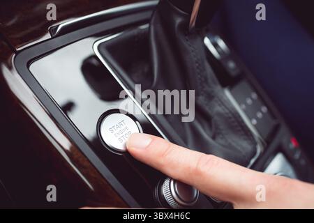 Man pressing start button in car Stock Photo