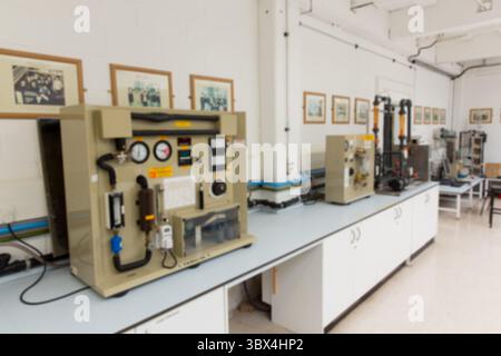 Beige testing apparatus is occupying workbench in flat design lab, showing gauges and tubing. Scientific, research, innovation, technical, precision, Stock Photo
