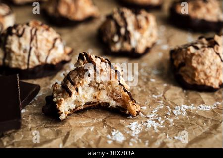 Macaroons Drizzled with Dark Chocolate on Unbleached Parchment Paper: Toasted coconut meringue drop cookies dipped in bittersweet chocolate close-up Stock Photo