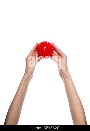 Massage red ball in female hand for trigger points isolated on a white background. Concept of myofascial release. Stock Photo
