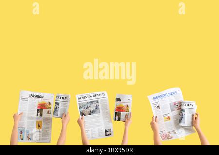 Women with newspapers on yellow background Stock Photo