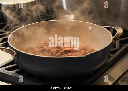 Steaming ground beef being sautéed in pan on stovetop Stock Photo