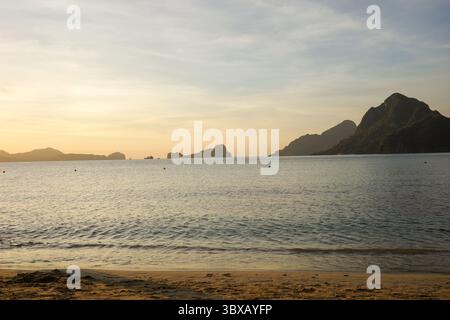 Landscape of a beautiful sunset in Vanilla beach, Coron, Palawan. The last sun ray of the day is the magical moment when the ocean feels warmer Stock Photo