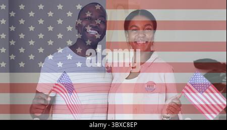 Smiling Black man and Asian woman holding US flags with VOTE badges at home, flag overlay Stock Photo