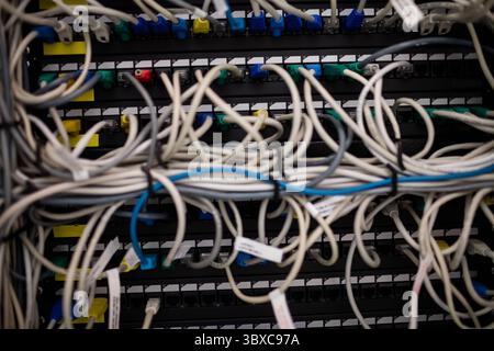 Network patch panel is being shown with tangled Ethernet cables and RJ45 connectors in flat design Stock Photo