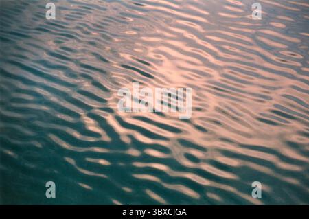 image of the surface water of a lake where you can see the ripples and reflections created by the water waves. Stock Photo
