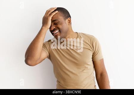 Black man with hand on forehead, reacting to problem Stock Photo
