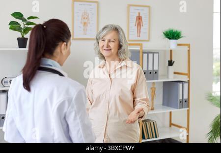 Happy, smiling senior woman talking to her nurse or doctor at the geriatric clinic Stock Photo