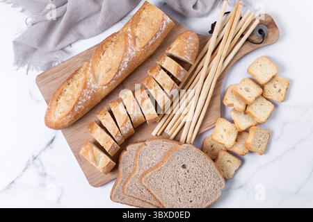 Assortment of Bread Products on white marble background Stock Photo