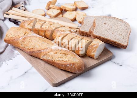 Assortment of Bread Products on white marble background Stock Photo