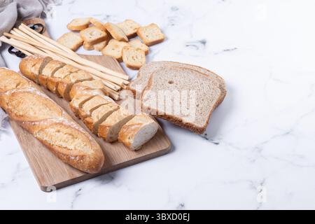 Assortment of Bread Products on white marble background Stock Photo