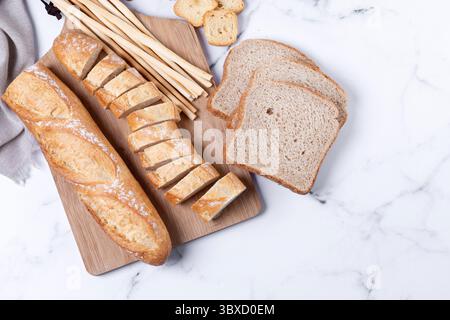 Assortment of Bread Products on white marble background Stock Photo