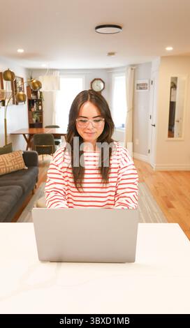 young woman works at laptop in apartment Stock Photo