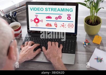 Video streaming concept shown on a laptop used by a man Stock Photo