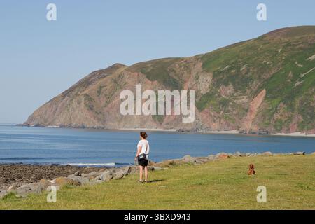 A woman & a dog out for fresh air and exercise at Lynmouth in North Devon, United Kingdom. Stock Photo