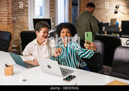 Multi ethnic team taking selfie in modern office Stock Photo