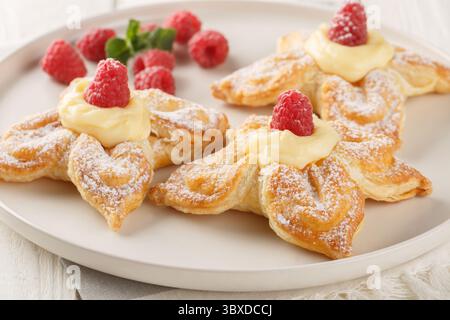 Delicious summer puff pastry with vanilla custard and fresh raspberries close-up in a plate on the table. Horizontal Stock Photo